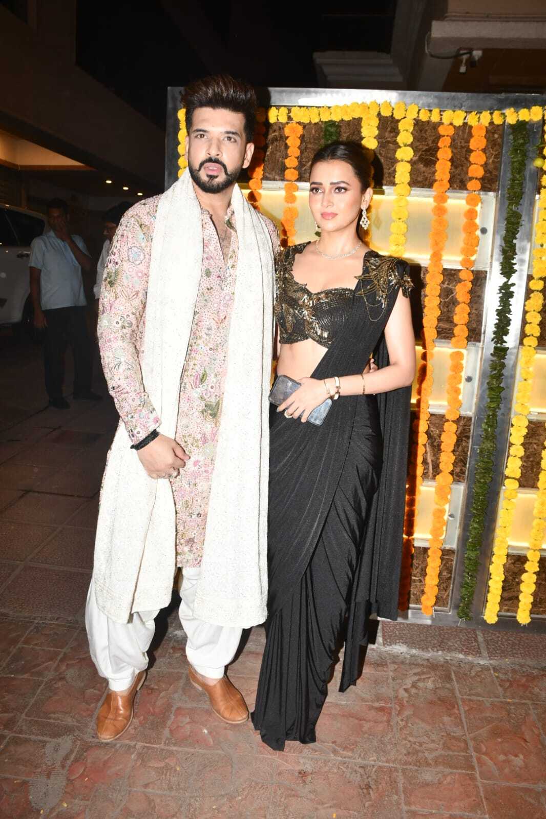 Karan Kundrra and Tejasswi Prakash looked extremely stylish, complimenting each other. Tejasswi Prakash wore a black saree, which she paired with a very fashionable sleeveless black blouse featuring golden-colored work She completed her look with a diamond choker necklace and a bun. Meanwhile, Karan Kundrra wore a light pink embroidered kurta with multicolor work.
